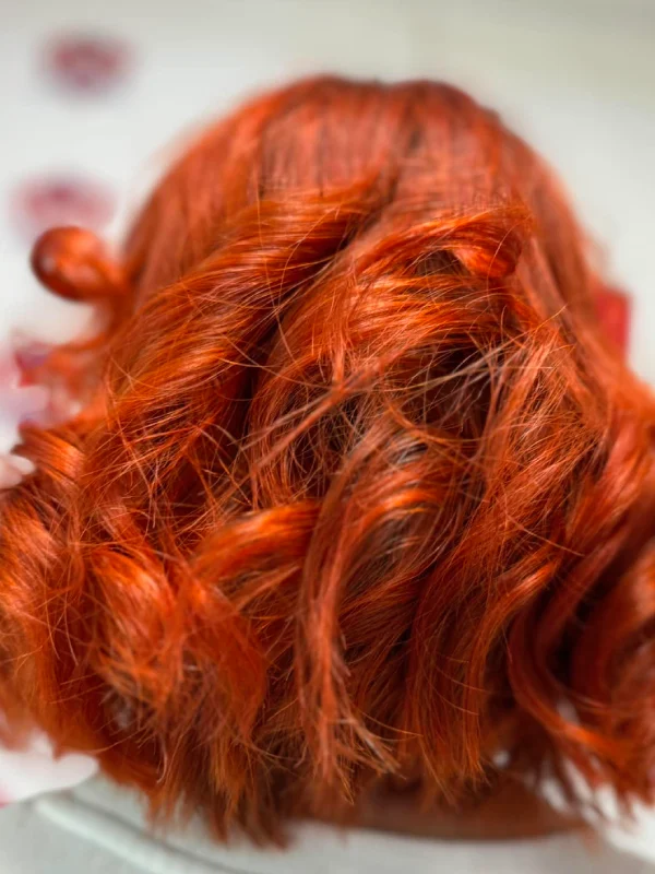 Reddish curly hair of a lady from behind at a beauty salon
